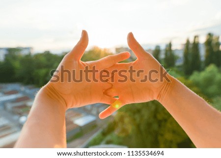 Gesture two hands together, background evening sunset, city silhouette