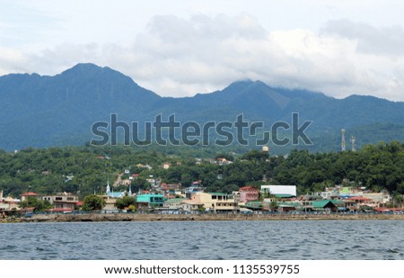 A Coastal Village in the Philippines and a mountain in the background. 