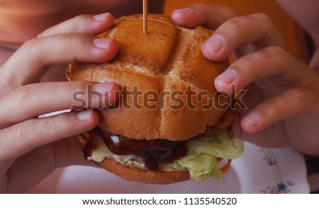 Young man eating a hamburger, Juicy and yummy hamburger
