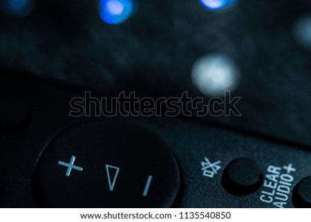Volume up and down buttons on a remote control, background, closeup sideview