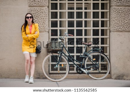 Happy woman walking in european street. Young attractive tourist outdoors in Vienna city on the piazzawith the bike