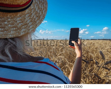 girl takes pictures of a wheat field