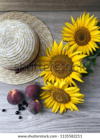 Straw Hat, peaches, sunflowers and current on the table