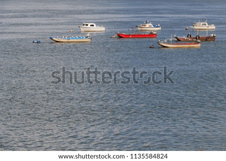 Small colorful fishing boats anchored in the river. Nature background. Blue water.
