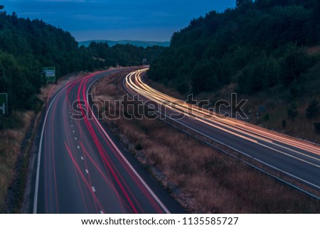 Night traffic on England’s motorways, with motion blurred light tracks glowing, right after sunset. Concept of traffic, transportation, travel, road safety, transport industry. Royalty-Free Stock Photo #1135585727