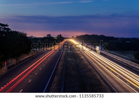 Night traffic on England’s motorways, with motion blurred light tracks glowing, right after sunset. Concept of traffic, transportation, travel, road safety, transport industry. Royalty-Free Stock Photo #1135585733