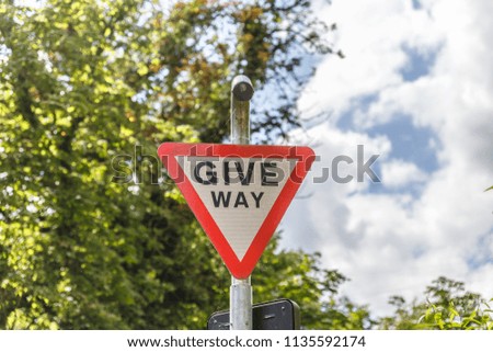 Traffic sign hanging on a pole indicating give way