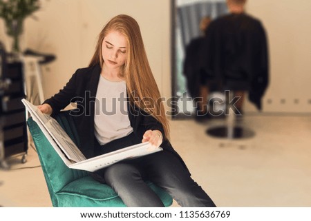 Pretty girl read book in hairdresser shop