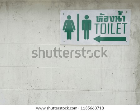 toilet sign on white brick wall