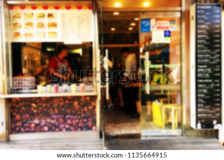 blur photo of front coffee shop is background.  This shop has many customers.And there are many menus.