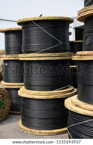 Wooden Coils Of Electric Cable Outdoor. High and low voltage cables in the storage. Royalty-Free Stock Photo #1135693937