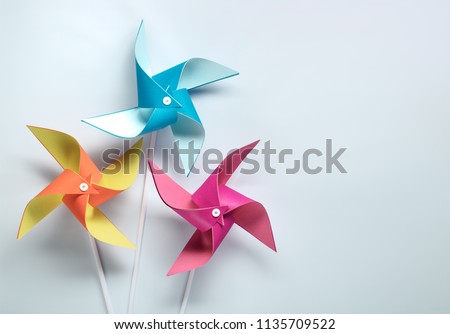 Multi colored pinwheel on paper background Royalty-Free Stock Photo #1135709522