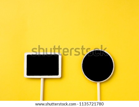 Wooden information label sign with circle and rectangle black empty place for text, Blank blackboard label isolated on yellow  background, Top view and copy space.