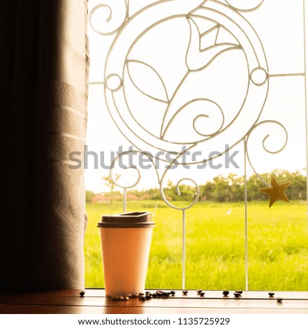 coffee cup put on wooden and in front of the window on fresh morning time