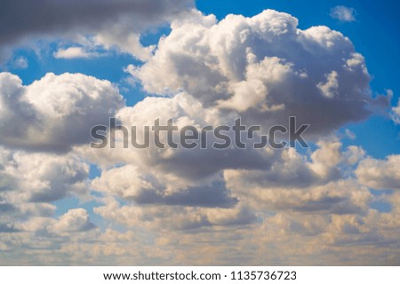 Beautiful dark clouds on a blue sky, background for design, sunny day