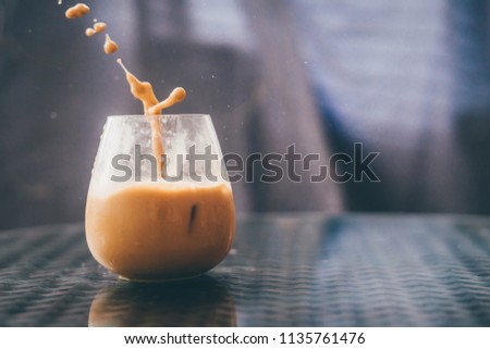 Pouring ice latte coffee in transparent glass
