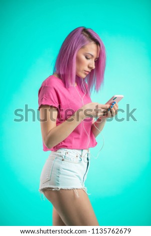 Concentrated woman downloading her photos with her new pink hair color to medial social net. Trendy Lifestyle, Technology, Beauty Concept.