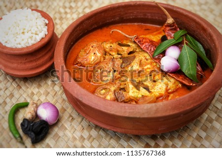 Very popular Kerala fish curry rice in coastal area south Indian and Sri Lanka, Malaysia, Thailand, Singapore. made by marinated mackerel fish with Indian spices and coconut milk. sea food in clay pot