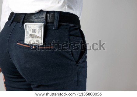Money, dollars in your pants pocket. The concept of corruption, bankruptcy, collateral, crime, bribery, fraud, auction