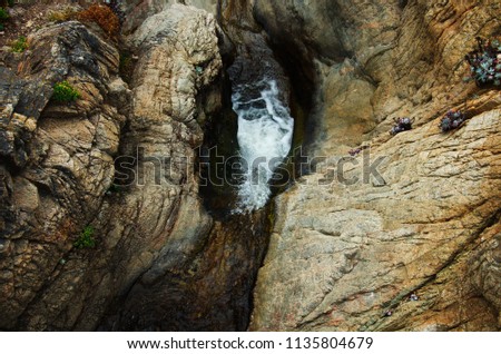 Above a waterfall with with rock formations around it