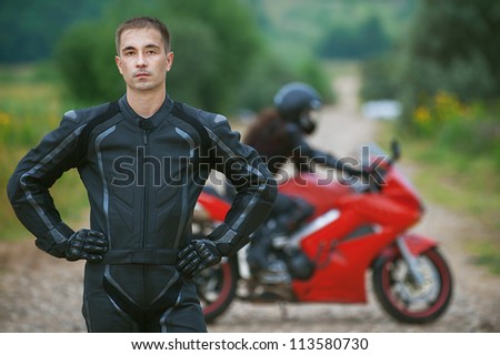 Young male motorcyclist on background of beautiful bike.