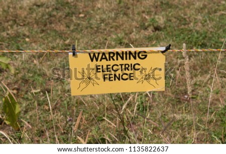 Warning Sign for an Electric Fence Around a Field of Livestock on a Farm in Rural Somerset, England, UK