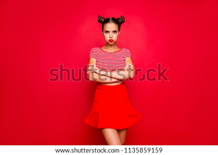Comedian humor joke concept. Portrait of grimacing funny capricious young woman model with bun hairstyle holding air in cheeks isolated on red background Royalty-Free Stock Photo #1135859159