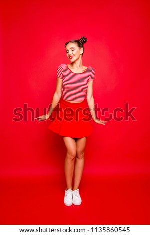 Full-legh and full-body vertical photo of charming, lovely and cute young girl isolated on red background