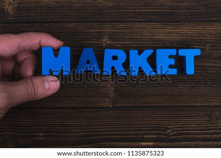 Hand and finger arrange text letters of MARKET word on wood table, with copy space for add advertising word or product. business and finance concept idea.