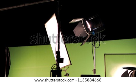 Big studio lighting kit 5000 watt with soft box on tripod and professional green screen background chroma key post production technique shooting or filming for movie or video commercial set up.
