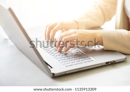 Close-up of hands typing on laptop keyboard at the office. Copy space. Worker, business, remote work, always connect, online banking concept. Soft focus. Sunlight bokeh effect.