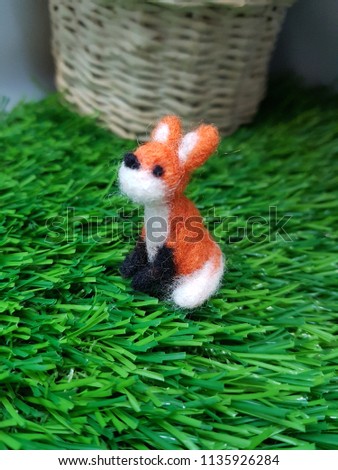 The fox doll is sitting on the garden