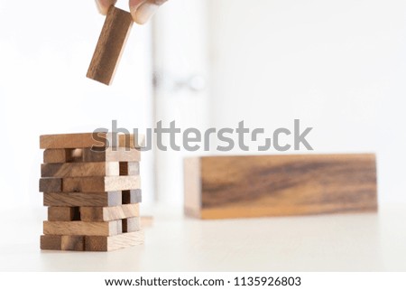 Hand arranging wood block stacking as step stair on table