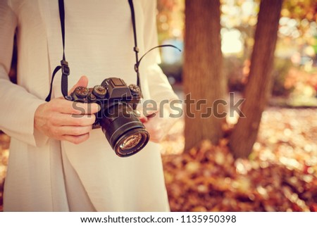 Girl with camera take a photo autumn