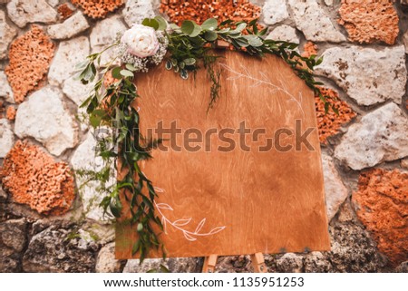 Wooden textured board, decorated with flowers, with empty space for text, sign, logo. Invitation board on wedding