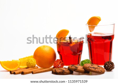 Drink or beverage with orange and cinnamon. Cocktail and bar concept. Mulled wine near slices of orange. Glasses with mulled wine or hot cider near orange slices and cookies on white background.