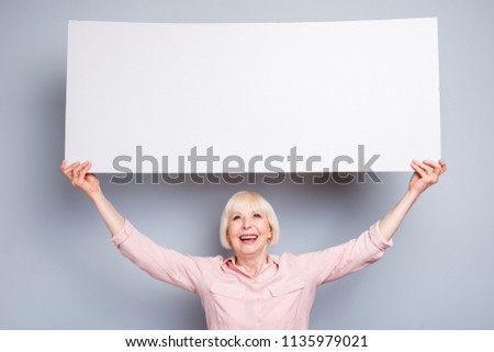 Positive happy old woman hold poster with empty space. Transparency concept with copyspace for text isolated on gray background