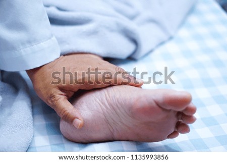 Doctor touching foot of Asian senior or elderly old lady woman patient with love, care, helping, encourage and empathy at nursing hospital ward : healthy strong medical concept 
             