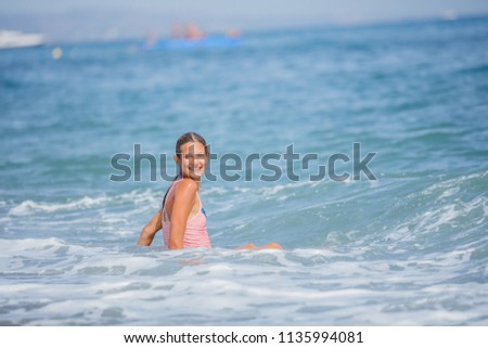 Beautiful girl in swimsuit having fun in the sea on tropical beach