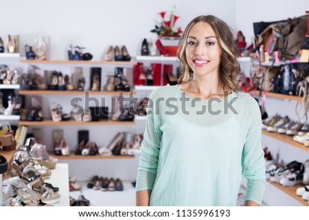 
Portrait of cheerful woman who is shopping in shoes shop.