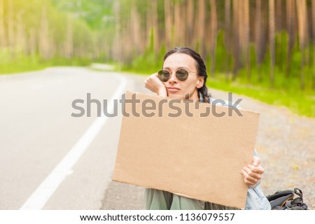 sad girl hitchhiking along a road