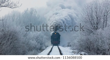 steam locomotive with steam clouds in winter, front view, Slovakia Royalty-Free Stock Photo #1136088500
