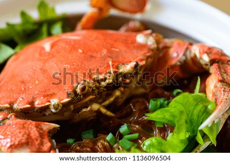 mud crab with glass noodles cooked and served in a clay pot