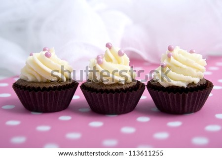 three cupcakes on pink backround