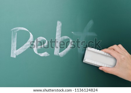 Erasing debt on a chalkboard.
 Royalty-Free Stock Photo #1136124824