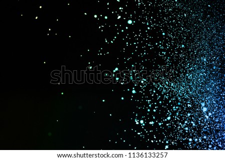 Painted Holi in festival,Freeze motion of color dust particles splash,Abstract multi color powder explosion on black background.