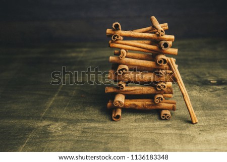 cinnamon sticks on a gold background. aromatic spices for drinks and baking. unusual food. cinnamon sticks on old wooden background, selective focus. stacked pyramid