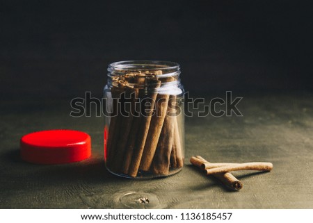 sticks of cinnamon on a gold background in a jar. aromatic spices for drinks and baking. unusual food. cinnamon sticks on old wooden background, selective focus. are composed of a pyramid. macro photo