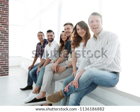 young creative people sitting on chairs in waiting room