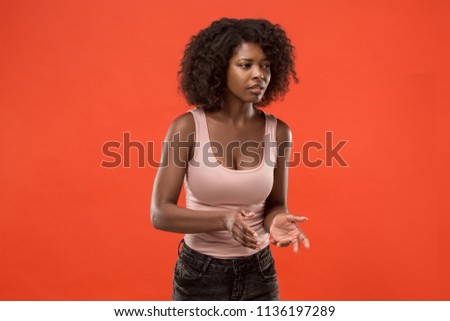 Argue, arguing concept. Beautiful female half-length portrait isolated on red studio backgroud. Young emotional surprised afro woman.Human emotions, facial expression concept. Front view
